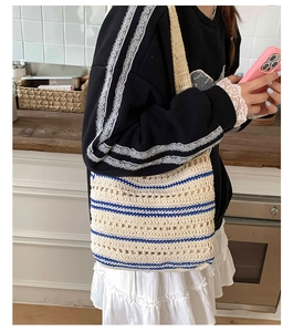 Detail view of beige and blue striped crochet tote bag with open-knit texture and long strap