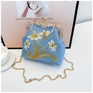 Detailed embroidery on light blue vintage kiss-lock bag with golden metal frame