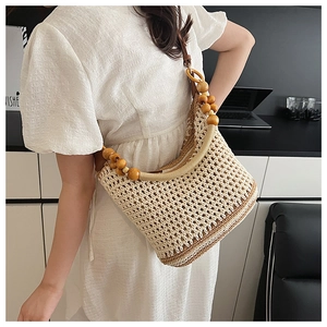 Détail du sac bandoulière tissé main avec perles en bois rustiques sur la sangle