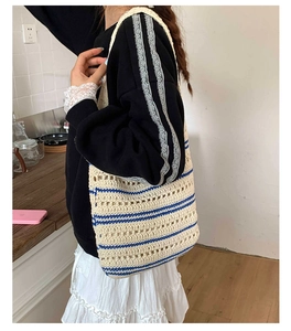 Detail of hand-crocheted tote bag with cream cotton texture and blue striped pattern