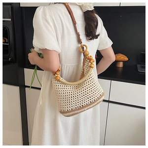 Détail d'un sac bandoulière en maille avec perles en bois et lanières en cuir