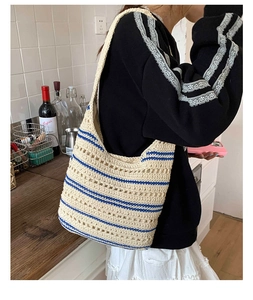 Detail of hand-crocheted striped cotton shoulder bag featuring hollow geometric patterns