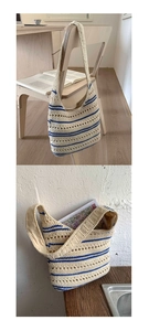 Close-up of beige and blue striped woven tote bag with a wide shoulder strap