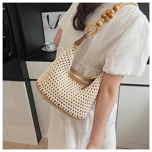Détail d'un sac à bandoulière tissé avec perles en bois et sangle à anneau décoratif