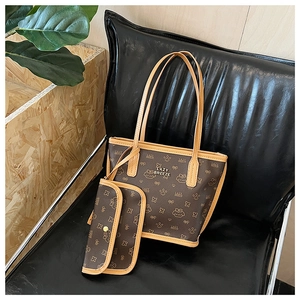 Close-up of brown tote and pouch set with cat monogram pattern and yellow piping