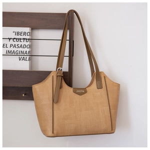 Detail of khaki woven tote bag showing adjustable brown straps and brand logo patch
