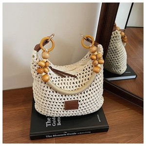 Détail du sac tissé à la main avec poignées en perles de bois et un écusson en cuir