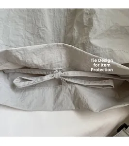 Detail view of the drawstring waist design on a casual light grey fabric shoulder bag