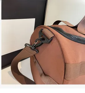 Détail du crochet pivotant et des coutures sur le sac de sport en nylon brun