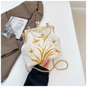 Close-up of vintage canvas embroidery bag with floral patterns and gold metal clasp