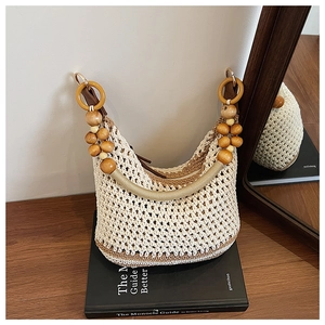 Détail du sac bandoulière bohème en tricot avec texture tissée et perles en bois