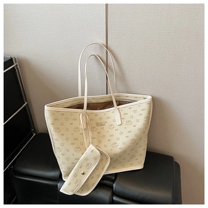 Detail of cream tote bag set featuring cartoon prints and a matching small zipper pouch