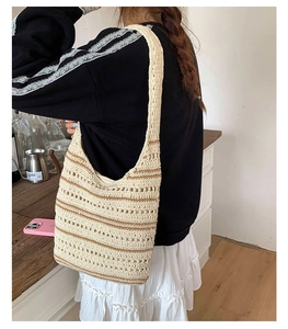 Detail of color-block knit tote bag with brown stripes and shoulder strap on model