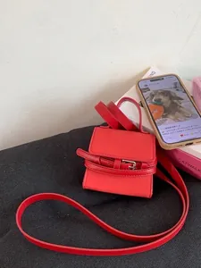 Mini red leather square handbag with belt buckle detail and slim crossbody strap
