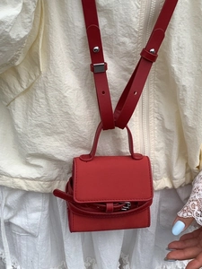 Mini red crossbody bag with top handle and adjustable strap in minimalist faux leather
