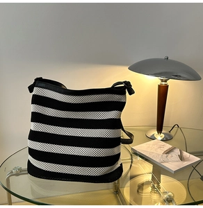 Dettaglio borsa tote in maglia a righe bianche e nere con finiture in pelle
