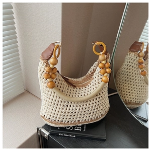 Texture de tricot détaillée d'un sac crochet beige avec poignées en bois et garniture cuir
