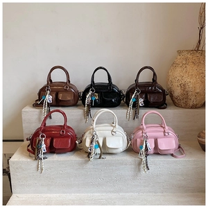 Detail of Boston-style leather bags in six colors with front pockets and silk scarves