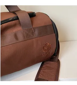 Détail de la broderie NINGJIA sur sac de sport en nylon marron café et texture souple