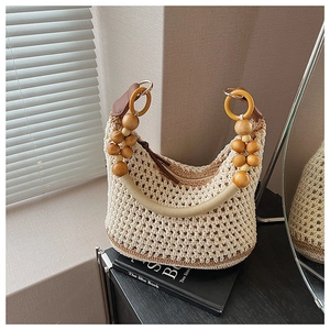 Détail du sac bohème en maille avec poignées en perles de bois naturel et jeux de lumière