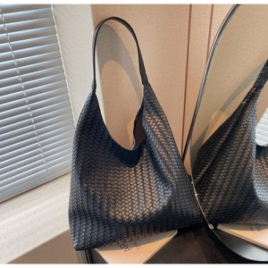 Detailed view of black woven leather hobo bag with classic intrecciato texture pattern