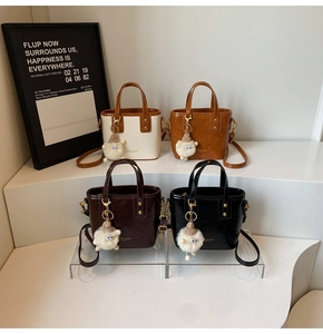 Four stylish faux leather bucket bags in beige, brown, and black with cute sheep charms