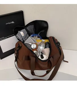Sac de sport marron large montrant un intérieur spacieux avec serviette et accessoires