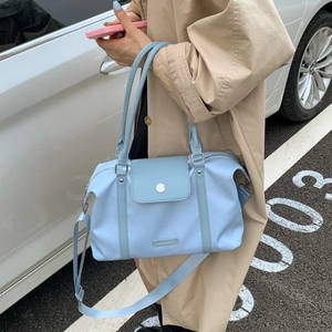 Sky blue travel bag with wide main zip and front pocket shown on a shoulder strap