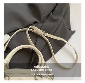 Detail of adjustable shoulder strap with metal buckle on beige leather handbag
