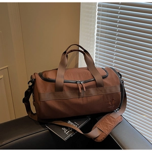 Vue détaillée du sac de sport marron imperméable avec poignées et bandoulière réglable