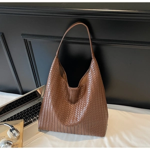 Detailed view of deep brown hand-woven leather texture on a large hobo tote bag