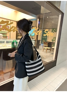 Dettaglio borsa hobo in maglia intrecciata a righe bianche e nere con tracolla in pelle