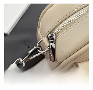 Close-up of silver metal hardware and high-quality stitching on a beige baguette bag