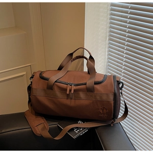 Détail d'un sac de sport marron avec poche latérale en filet et poignées solides