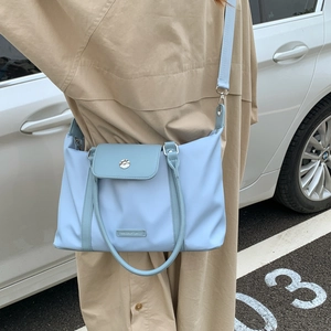 Close-up of light blue travel bag with adjustable strap and metal buckle detail
