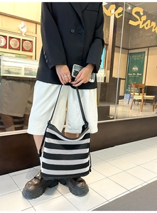 Dettaglio di una borsa tote a rete a righe bianche e nere con outfit in stile urban chic