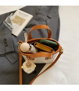 Minimalist bucket bag interior showing capacity for phone, umbrella, and wallet
