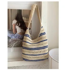 Detail of hand-woven crochet shoulder bag with beige and blue stripes in a lifestyle setting