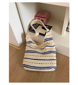 Detail showing the intricate hollow weave texture and blue stripes of the woven tote bag
