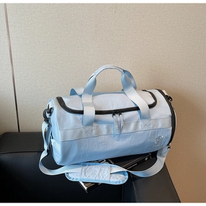 Détail du sac de sport bleu clair imperméable avec sangles noires sur siège en cuir