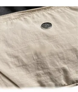 Close-up of lightweight textured nylon fabric with a round silver decorative metal buckle