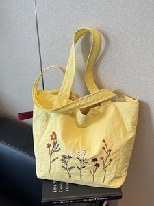 Large bright yellow tote bag with floral embroidery and natural pleated texture surface