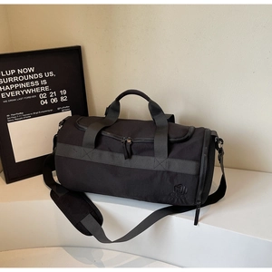 Vue détaillée du sac de sport noir avec poche latérale en filet et bandoulière réglable