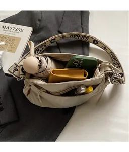 Top view of beige nylon crossbody bag showing spacious interior with daily essentials