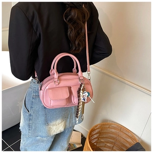 Dettaglio della mini borsa lucida rosa acceso con ciondoli indossata vista da dietro