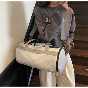 Détail du sac de sport blanc cassé avec côté en maille respirante et logo de marque