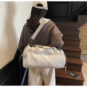 Gros plan d'un sac de sport en toile blanche avec sangles grises et logo sur un mannequin