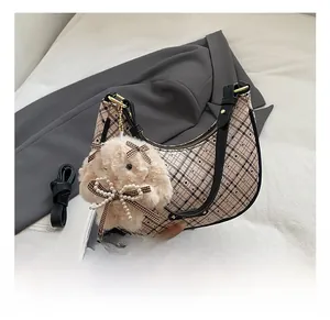Detail of retro plaid crescent bag with gold hardware and plush rabbit charm
