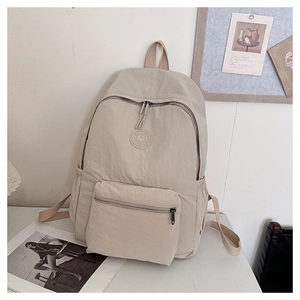 Vue détaillée du tissu beige résistant à l'eau et de l'emblème SPORT du sac
