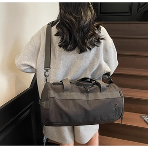 Détail du sac de sport gris durable avec poignées renforcées et crochets de sangle en métal